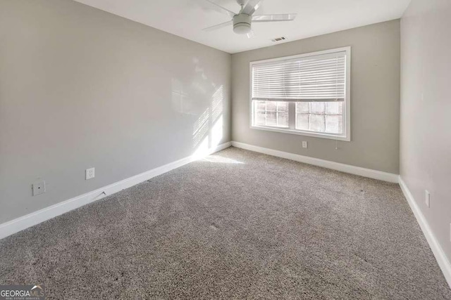 unfurnished room featuring carpet, visible vents, baseboards, and a ceiling fan