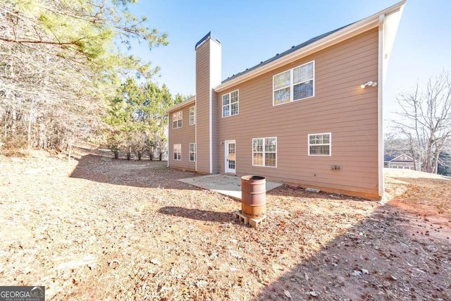 rear view of property with a patio and a chimney