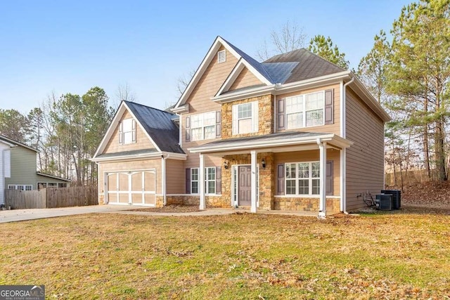 craftsman inspired home with driveway, stone siding, fence, a front lawn, and central AC