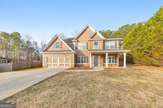 view of front of home featuring fence, a garage, stone siding, driveway, and a front lawn