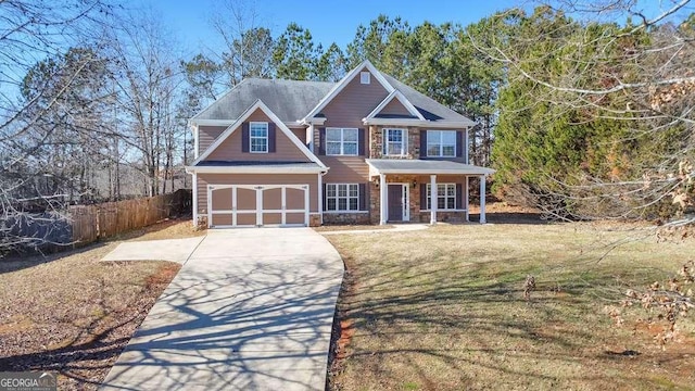 view of front of property featuring stone siding, fence, driveway, and a front lawn