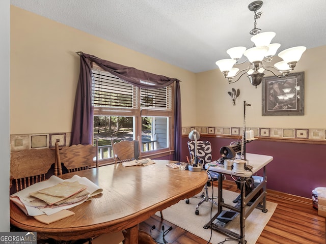 office area featuring a textured ceiling, wood finished floors, and an inviting chandelier