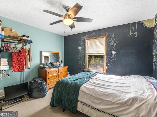 carpeted bedroom featuring ceiling fan and a textured ceiling