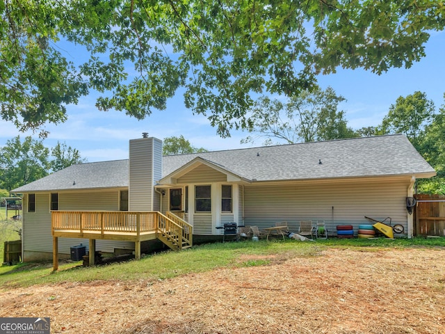 back of house featuring roof with shingles, a chimney, fence, cooling unit, and a wooden deck