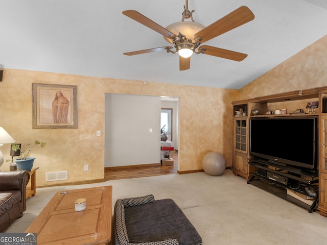 living room featuring ceiling fan, light carpet, visible vents, baseboards, and vaulted ceiling