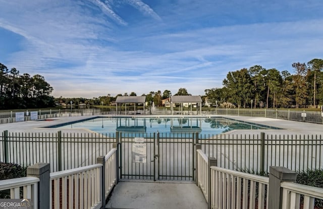 community pool featuring fence and a patio