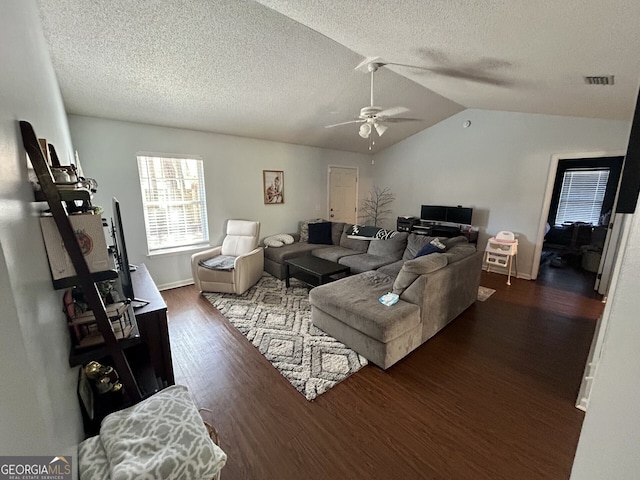 living room featuring visible vents, a ceiling fan, wood finished floors, vaulted ceiling, and a textured ceiling