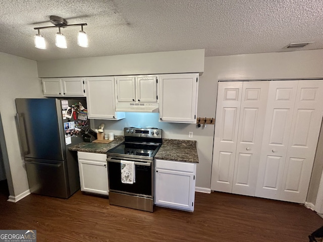 kitchen featuring dark countertops, dark wood-style flooring, stainless steel appliances, under cabinet range hood, and white cabinetry