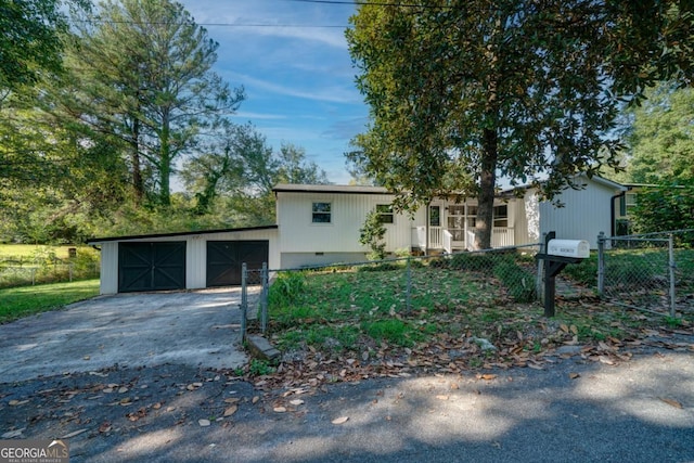 view of front of house with driveway, fence, and an outbuilding