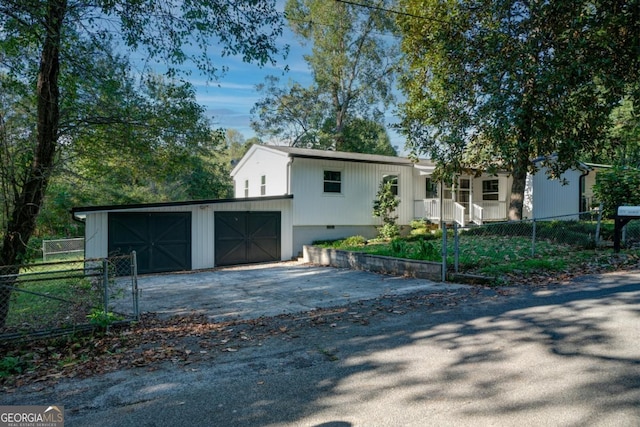 view of front of home featuring a garage, fence, and aphalt driveway