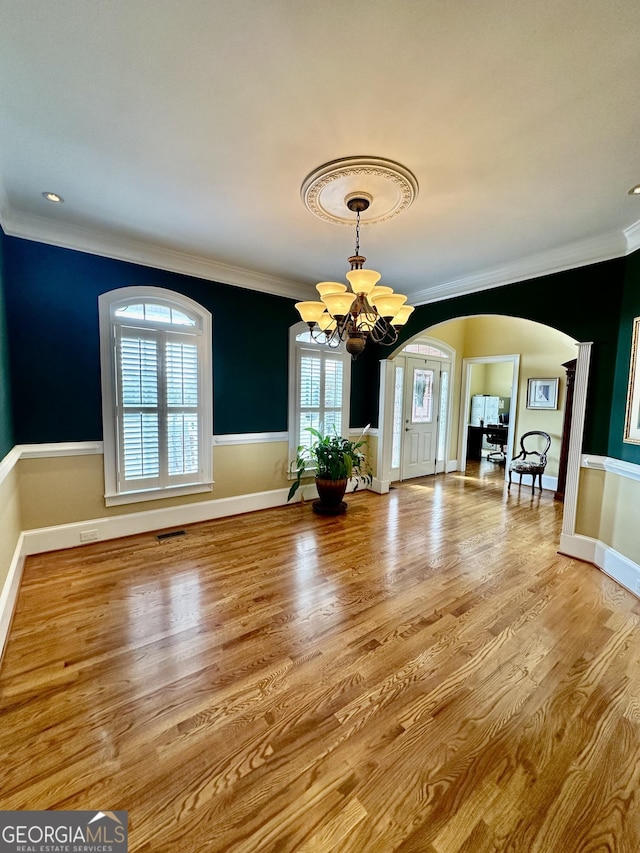 3585 Shepherds Ln, Loganville, GA 30052 - unfurnished dining area with arched walkways, a chandelier, wood finished floors, baseboards, and ornamental molding