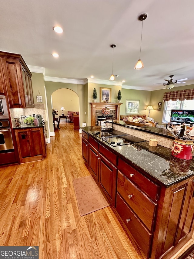 3585 Shepherds Ln, Loganville, GA 30052 - kitchen featuring light wood finished floors, arched walkways, open floor plan, oven, and black electric cooktop