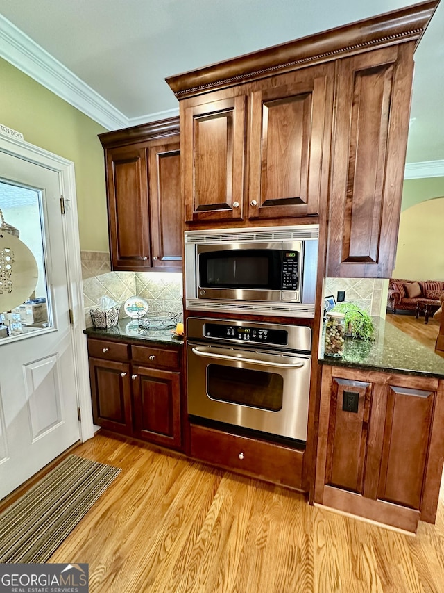 3585 Shepherds Ln, Loganville, GA 30052 - kitchen featuring light wood finished floors, ornamental molding, stainless steel appliances, and backsplash