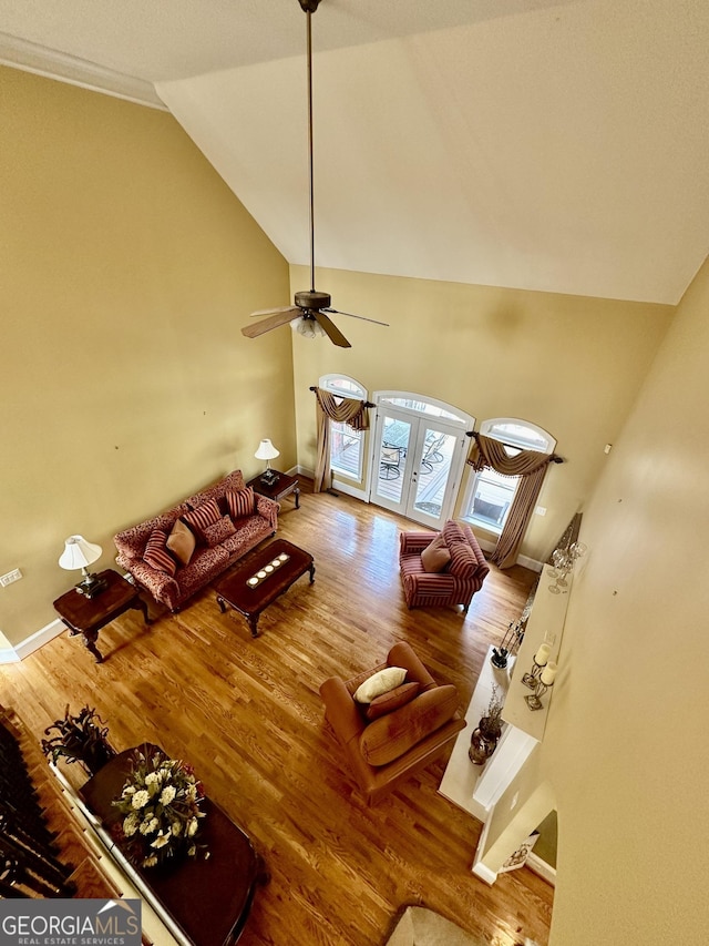 3585 Shepherds Ln, Loganville, GA 30052 - unfurnished living room with baseboards, ceiling fan, high vaulted ceiling, and wood finished floors