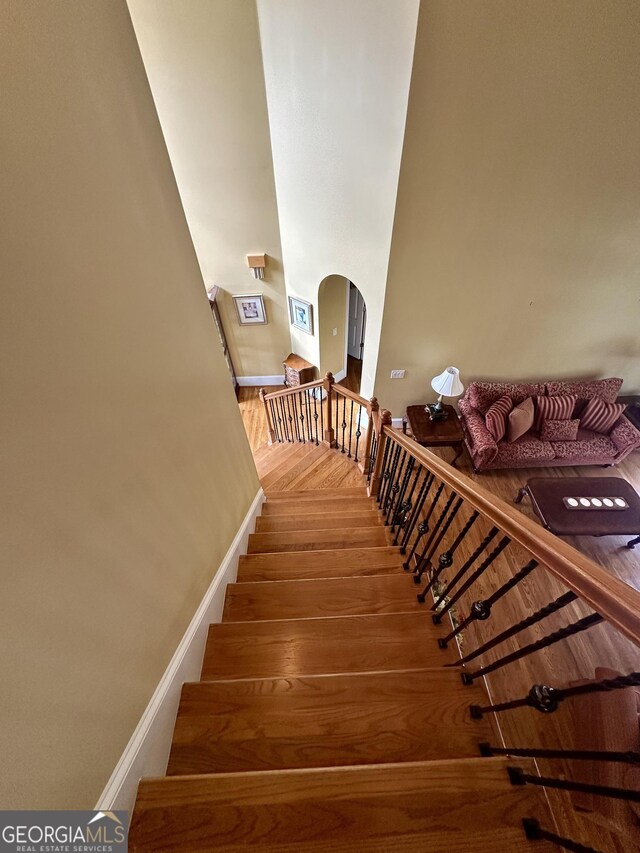 3585 Shepherds Ln, Loganville, GA 30052 - stairs with arched walkways, wood finished floors, and baseboards