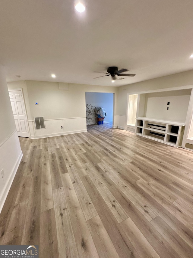 3585 Shepherds Ln, Loganville, GA 30052 - unfurnished living room with a ceiling fan, a wainscoted wall, visible vents, and wood finished floors
