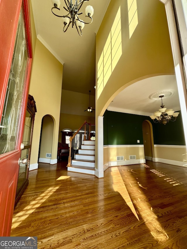 3585 Shepherds Ln, Loganville, GA 30052 - entrance foyer with an inviting chandelier, stairs, arched walkways, and wood finished floors