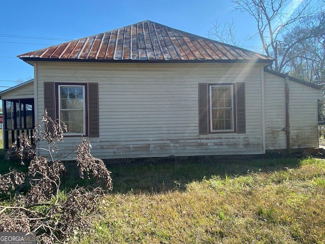 view of side of home featuring a standing seam roof and metal roof