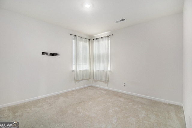 unfurnished room featuring carpet, visible vents, and baseboards