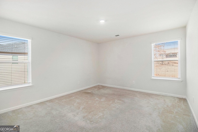 spare room with recessed lighting, baseboards, and light colored carpet