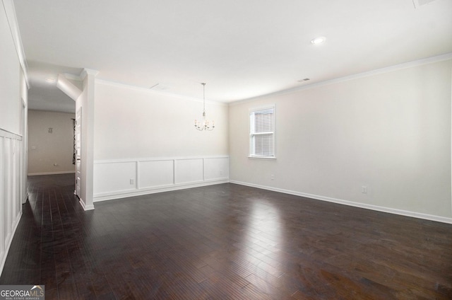 unfurnished room featuring dark wood-style floors, a chandelier, crown molding, and baseboards