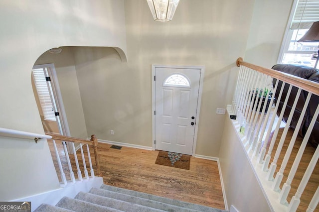 entryway featuring visible vents, plenty of natural light, stairway, and wood finished floors