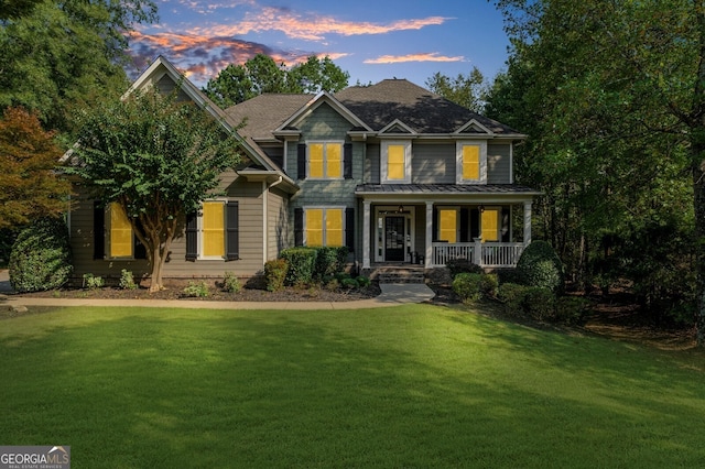 view of front of house with a standing seam roof, a porch, and a yard