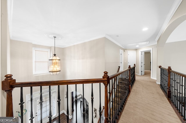 corridor featuring baseboards, carpet flooring, an upstairs landing, and crown molding