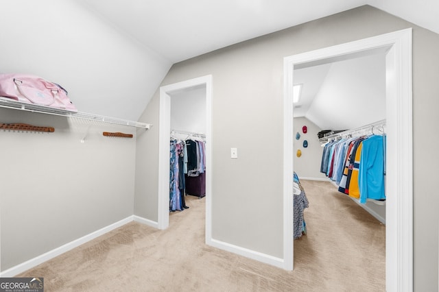 walk in closet with carpet floors and lofted ceiling