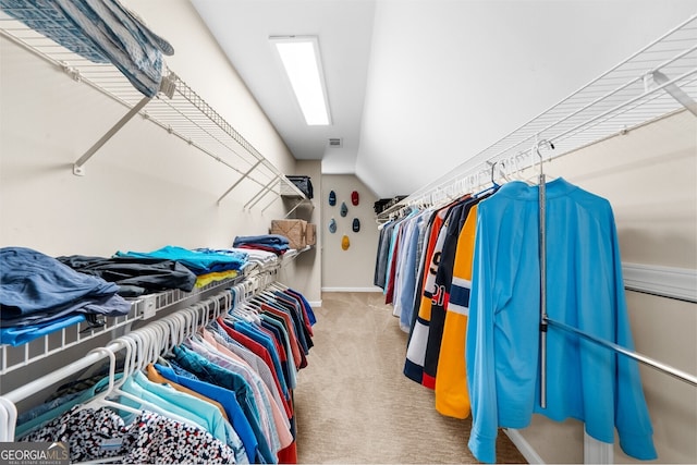 spacious closet with vaulted ceiling, carpet floors, and visible vents