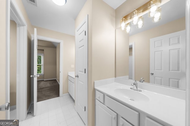 bathroom featuring tile patterned flooring, vanity, visible vents, and baseboards