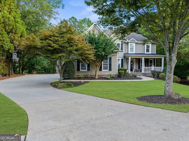 view of front of property with covered porch, a front lawn, and concrete driveway