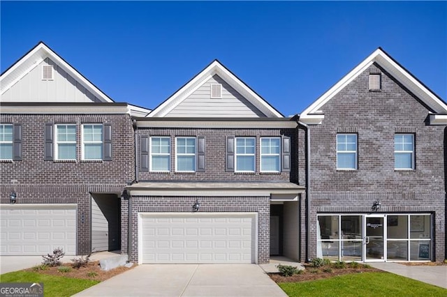 multi unit property with driveway, a garage, board and batten siding, and brick siding