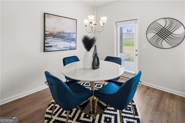 dining area featuring an inviting chandelier, baseboards, and wood finished floors