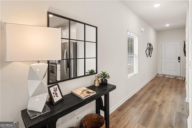 hallway featuring recessed lighting, wood finished floors, and baseboards