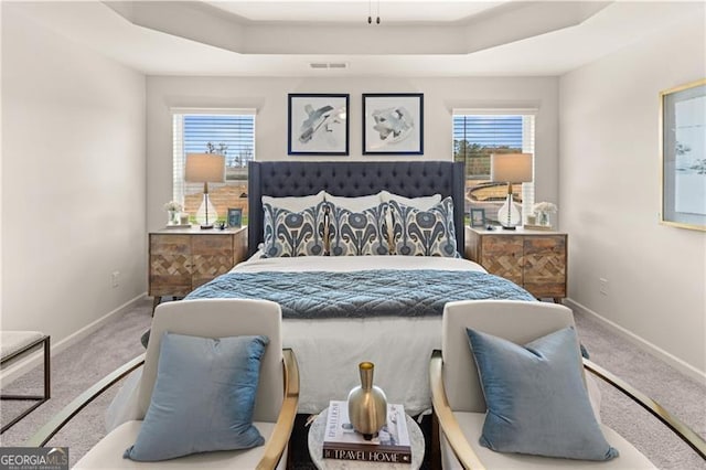 bedroom featuring a raised ceiling, visible vents, and carpet flooring