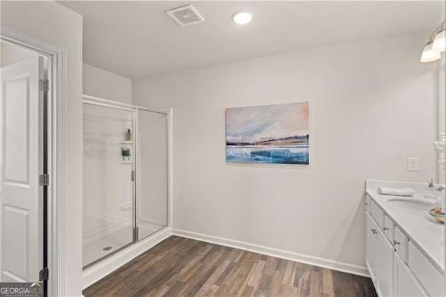 bathroom featuring visible vents, a shower stall, vanity, wood finished floors, and baseboards