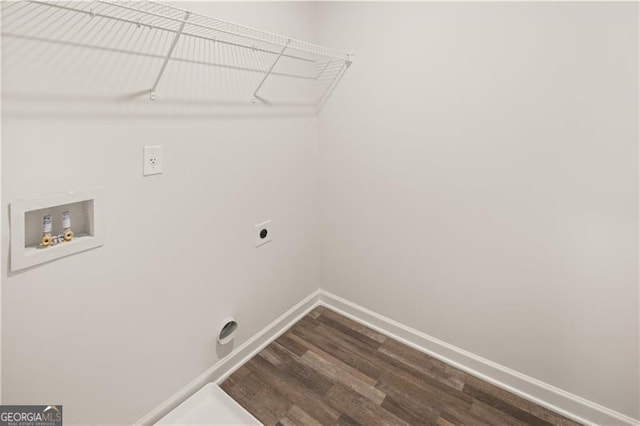 clothes washing area featuring laundry area, baseboards, dark wood-type flooring, washer hookup, and electric dryer hookup