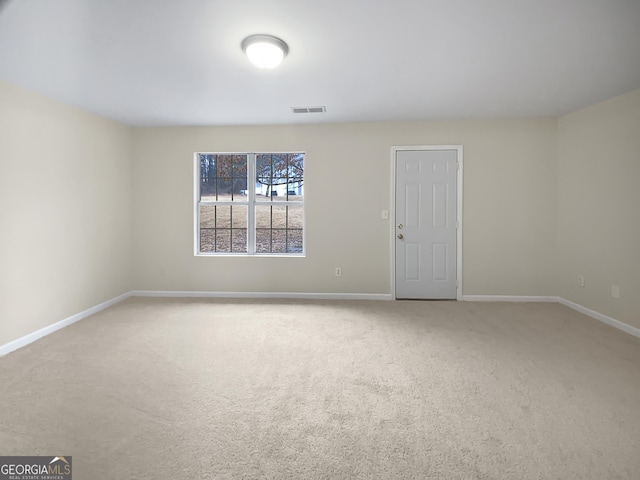 carpeted spare room featuring visible vents and baseboards