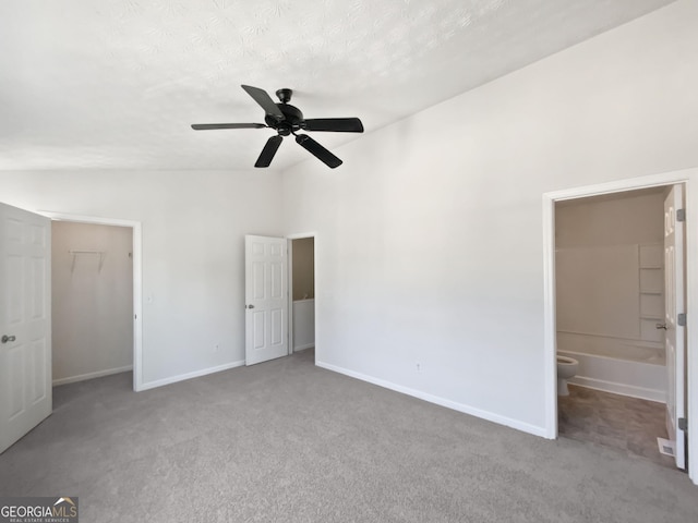 11403 S Grove Dr, Hampton, GA 30228 - unfurnished bedroom featuring lofted ceiling, carpet flooring, a walk in closet, ensuite bathroom, and a closet