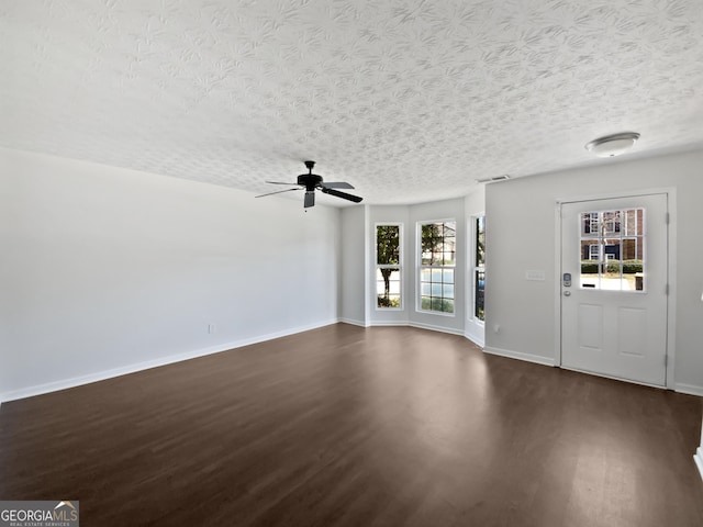 entryway featuring dark wood-style floors, a ceiling fan, baseboards, and a textured ceiling