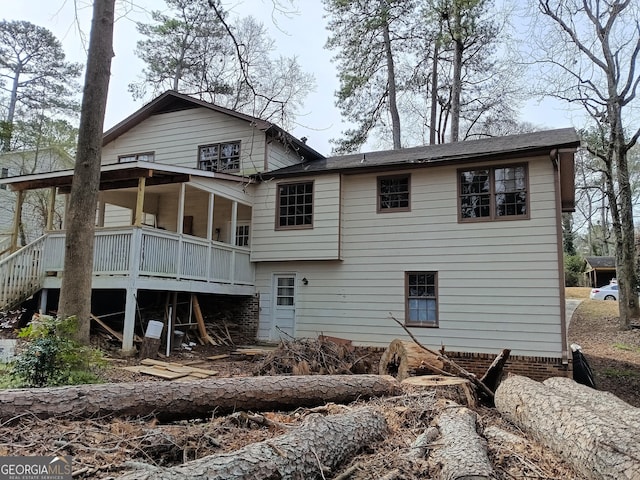 rear view of house featuring a sunroom and stairs