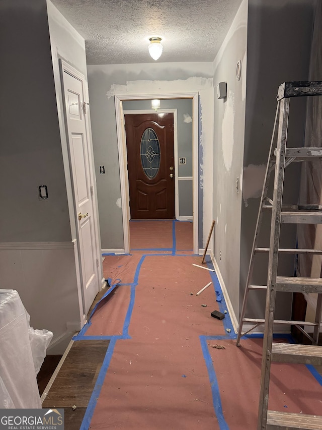 hall featuring a textured ceiling