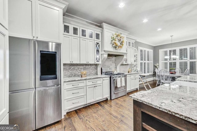 kitchen with decorative backsplash, dark wood-style floors, appliances with stainless steel finishes, ornamental molding, and a sink