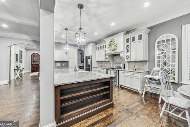 kitchen with arched walkways, stainless steel appliances, dark wood-style floors, tasteful backsplash, and crown molding