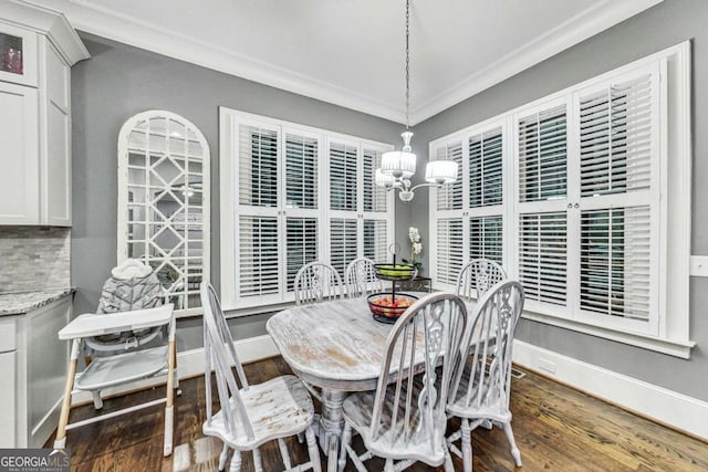 dining area featuring ornamental molding, wood finished floors, baseboards, and an inviting chandelier