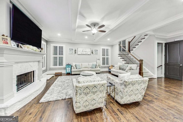 living room featuring dark wood finished floors, crown molding, recessed lighting, a premium fireplace, and stairs