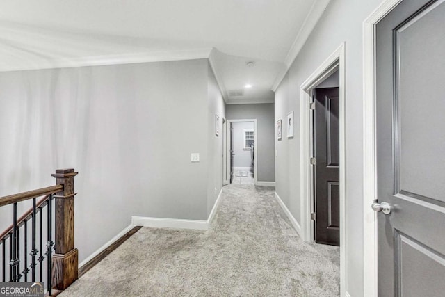 hall featuring baseboards, carpet flooring, an upstairs landing, and crown molding