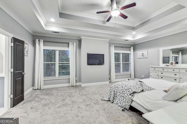 bedroom with carpet floors, baseboards, a tray ceiling, and crown molding