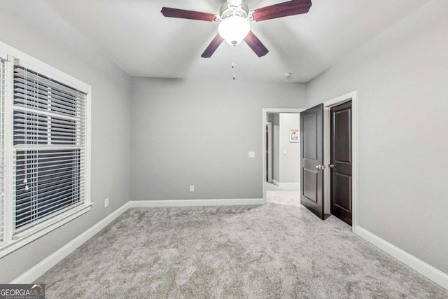 unfurnished bedroom featuring ceiling fan, carpet, and baseboards